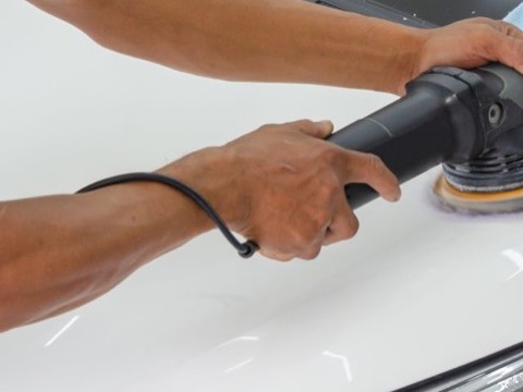 Polishing a car hood with a rotary buffer