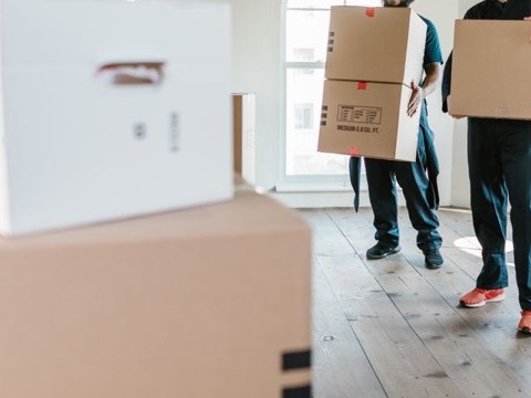 Movers carrying boxes into a home