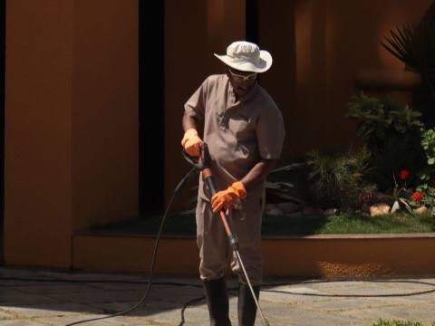 Worker pressure washing a home walkway