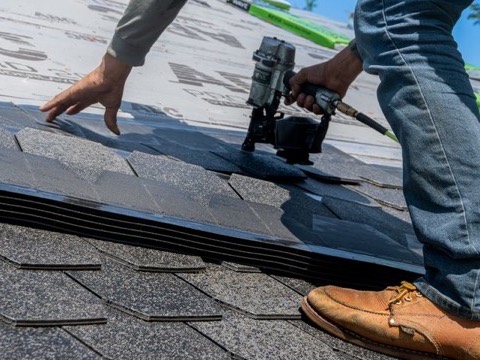 Roofer installing shingles